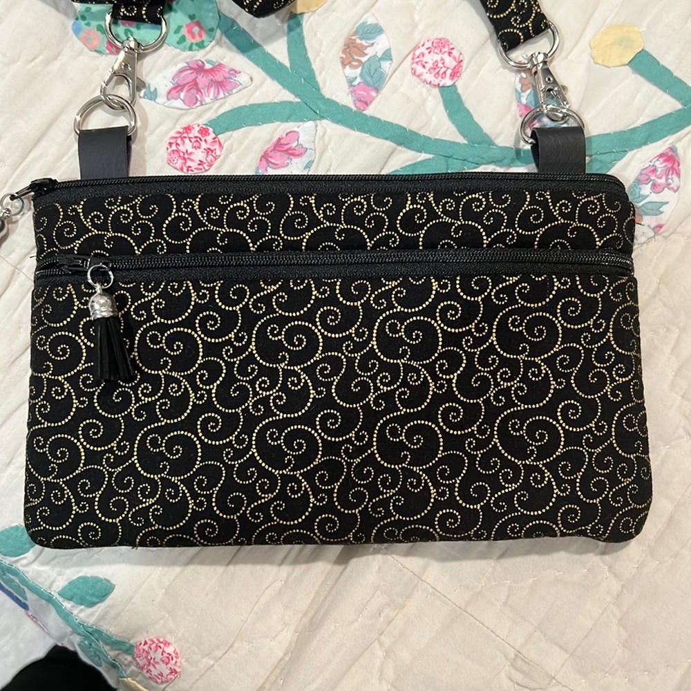 Black and gold cross body with removable straps and tassels to zipper sections